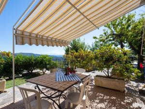 un tavolo e sedie sotto un ombrellone su un patio di Apartment Viola - VLO203 by Interhome a Lecchiore