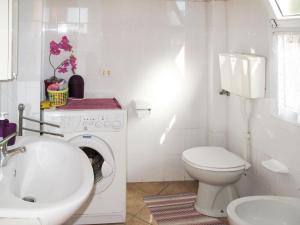 baño blanco con lavadora y lavamanos en Apartment Roma - SLR219 by Interhome, en Cipressa