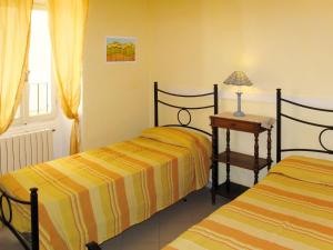 1 dormitorio con 2 camas y mesa con lámpara en Apartment Roma - SLR219 by Interhome, en Cipressa