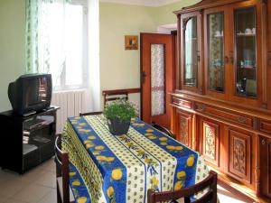 a dining room with a table with a plant on it at Apartment Roma - SLR219 by Interhome in Cipressa