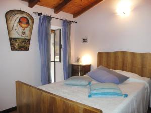 a bedroom with a bed with blue pillows on it at Holiday Home Angela - DOL100 by Interhome in Dolcedo +17 photos