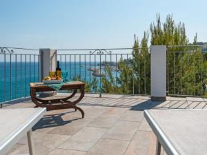 een tafel met een fles wijn en fruit op een balkon bij Apartment Silvia - SLR351 by Interhome in Imperia