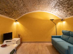 ヴェンティミリアにあるApartment Ernestina by Interhomeの青いソファと黄色の壁が特徴のリビングルーム