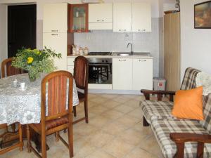 een woonkamer met een tafel en een keuken bij Holiday Home Casa Simona - DOL134 by Interhome in Costa Carnara