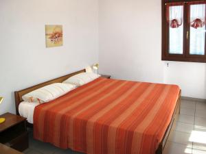 Costa CarnaraにあるApartment Marisa - DOL126 by Interhomeのベッドルーム1室(大型ベッド1台、ストライプ毛布付)