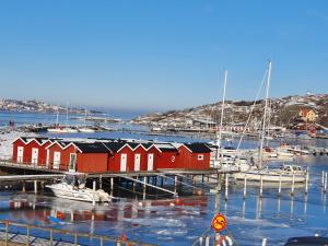 SkarvikにあるSkärgårdsidyll på Björkö med gångavstånd till havetの赤い家と水中の船を持つマリーナ