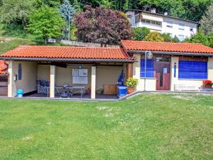 a small house with blue doors and a yard at Apartment Bellavista Erika 19 by Interhome in Cademario