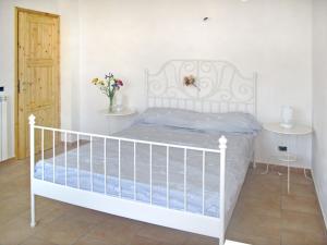 un letto bianco in una camera bianca con fiori in un vaso di Apartment Pia - PRE173 by Interhome a Praelo