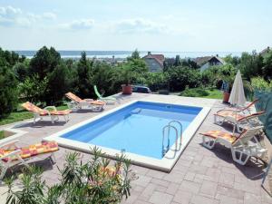 einen Pool auf einer Terrasse mit Liegestühlen in der Unterkunft Holiday Home Annemarie - ALD317 by Interhome in Balatonalmádi