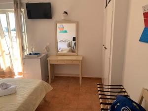 a bedroom with a mirror and a table and a bed at A Hotel Faros in Spetses