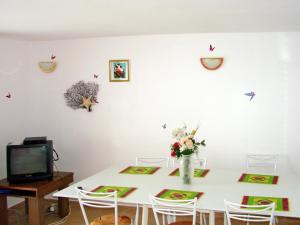 ein Esszimmer mit einem weißen Tisch mit Blumen und Vögeln an der Wand in der Unterkunft Holiday Home Annemarie - ALD317 by Interhome in Balatonalmádi