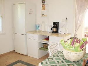 kuchnia z białą lodówką i stołem w obiekcie Holiday Home Annemarie by Interhome w mieście Balatonalmádi