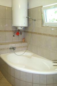 a white bath tub in a bathroom with a window at Holiday Home Rakoczi - MAF139 by Interhome in Balatonmáriafürdő