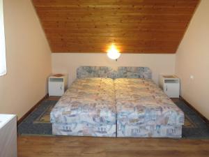duże łóżko w pokoju z drewnianym sufitem w obiekcie Holiday Home Rakoczi - MAF139 by Interhome w mieście Balatonmáriafürdő