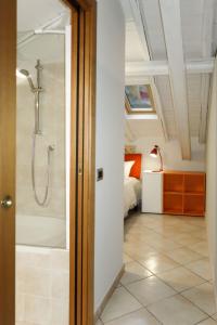 uma casa de banho com uma cabina de duche ao nível do chão ao lado de uma cama em Apartment del Sole-3 by Interhome em Luino