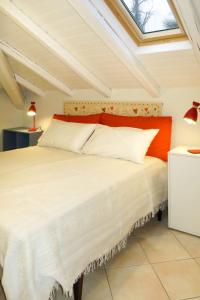um quarto com uma grande cama branca e uma clarabóia em Apartment del Sole-3 by Interhome em Luino