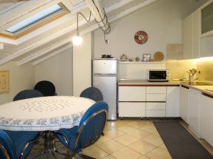 kuchnia ze stołem, krzesłami i lodówką w obiekcie Apartment del Sole-3 by Interhome w mieście Luino