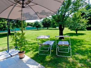 a table and two chairs under an umbrella at Holiday Home di Pipot by Interhome in Pettenasco