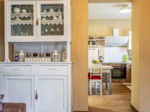 a kitchen with white cabinets and a dining room at Holiday Home di Pipot by Interhome in Pettenasco