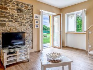 a living room with a tv and a stone wall at Holiday Home di Pipot by Interhome in Pettenasco +21 photos