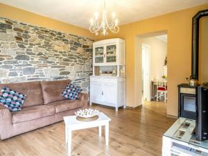 a living room with a couch and a stone wall at Holiday Home di Pipot by Interhome in Pettenasco
