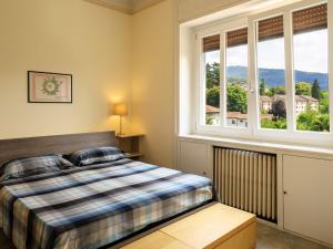 um quarto com uma cama e duas janelas em Apartment del Sole-2 by Interhome em Luino