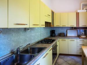 uma cozinha com armários amarelos e um lavatório de aço inoxidável em Apartment del Sole-2 by Interhome em Luino
