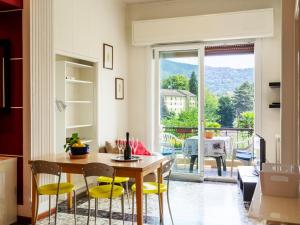 a kitchen with a table and chairs and a balcony at Apartment del Sole-2 by Interhome in Luino