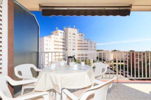 a white table and chairs on a balcony with a building at Apartamento Vora Mar 33 in Cambrils