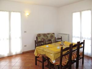 ein Esszimmer mit einem gelben Tisch und Stühlen in der Unterkunft Apartment La Colombera - DIA142 by Interhome in Diano Castello