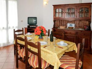 a dining room with a table and a tv at Apartment La Colombera - DIA142 by Interhome in Diano Castello