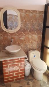 bagno con lavandino, servizi igienici e specchio di Asian House a Uyuni