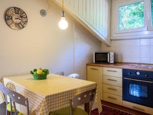 een keuken met een tafel met een magnetron en een tafel met stoelen bij Apartment del Sole-4 by Interhome in Luino