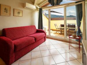 een woonkamer met een rode bank en een balkon bij Apartment del Sole-4 by Interhome in Luino