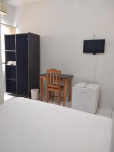Habitación con mesa, silla y TV. en Fabiel Palace Hotel en Cuiabá