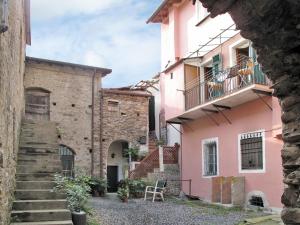 a view of a pink building with stairs and a balcony at Apartment Limone by Interhome in Dolcedo