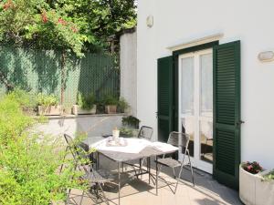 stół i krzesła na patio z zielonymi drzwiami w obiekcie Holiday Home Gaia by Interhome w mieście Bellano