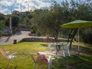 una mesa y sillas con una sombrilla verde en un patio en Apartment Joy - IMP521 by Interhome, en Imperia 29 fotos más