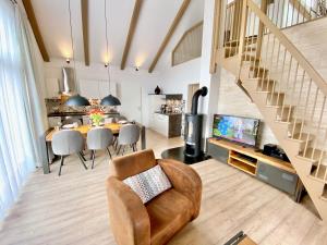 a dining room and living room with a table and a television at mönchgut living & spa in Gager