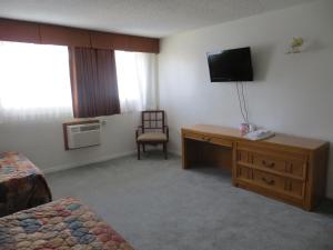 a hotel room with a television and a desk with a chair at Jet Inn in Los Angeles
