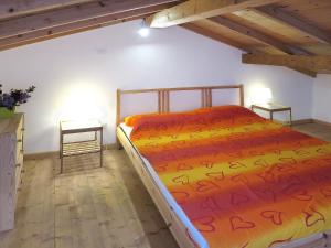 PraeloにあるHoliday Home La Canonica - PRE190 by Interhomeのベッドルーム1室(オレンジのシーツとテーブル2台付)