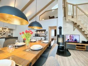 a dining room with a table and a tv at mönchgut living & spa in Gager