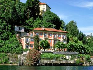 a large building on a hill next to the water at Studio Casa sul lago by Interhome in Orta San Giulio