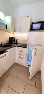 a kitchen with white cabinets and an open refrigerator at Fewo Traum in Neppermin
