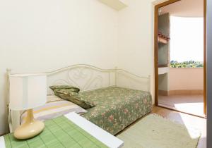 sypialnia z łóżkiem z lampką i lustrem w obiekcie Apartment Penetra w mieście Cavtat