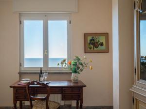 een tafel met een vaas met bloemen en een raam bij Apartment Primavera - PGI130 by Interhome in Poggi