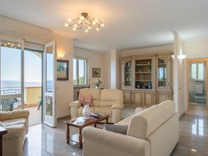 een woonkamer met witte meubels en uitzicht op de oceaan bij Apartment Primavera - PGI130 by Interhome in Poggi