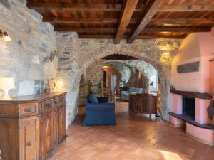 Holiday Home U Figu du Camin by Interhome في Villa Viani: غرفة معيشة كبيرة بجدار حجري