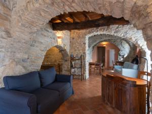 Holiday Home U Figu du Camin by Interhome في Villa Viani: غرفة معيشة مع أريكة في جدار حجري