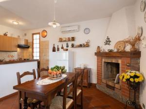 Diano San PietroにあるHoliday Home Casa Paolo by Interhomeのキッチン、ダイニングルーム(テーブル、暖炉付)